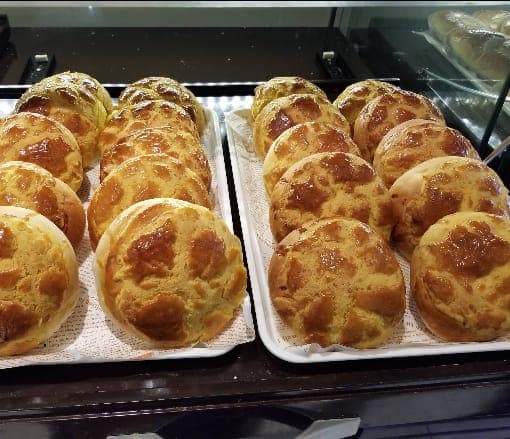 Trays of pineapple buns with crackly golden tops in the display case
