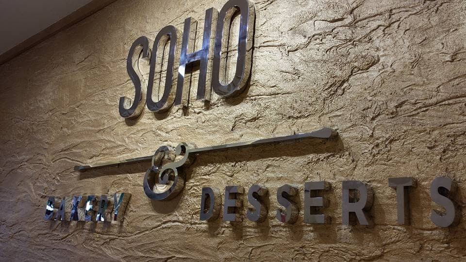 The polished SOHO Bakery & Desserts lettering on the shop's textured feature wall